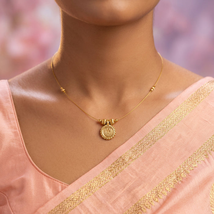 A delicate gold chain necklace with a central round medallion pendant and small bead accents, displayed on a light gray jewelry bust.